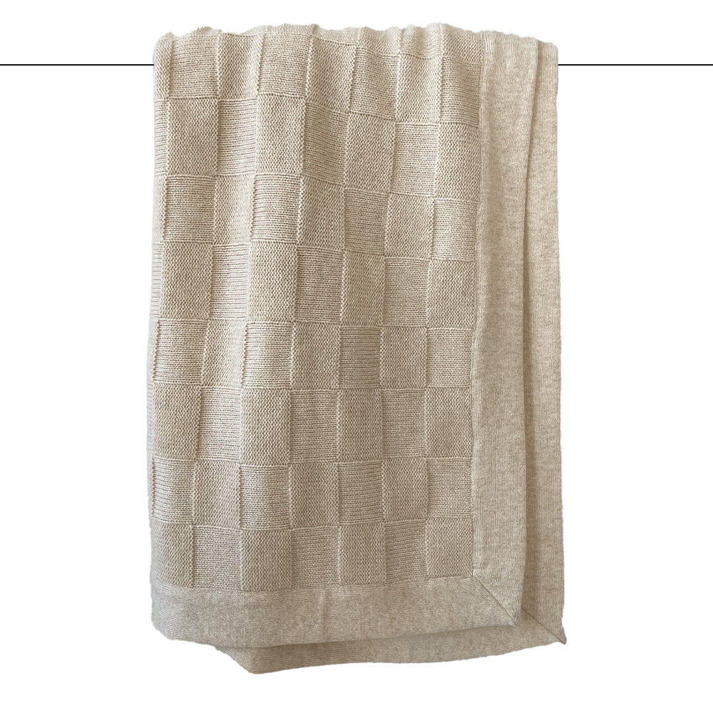 A beige throw blanket with a classic checkers pattern, draped and displayed.